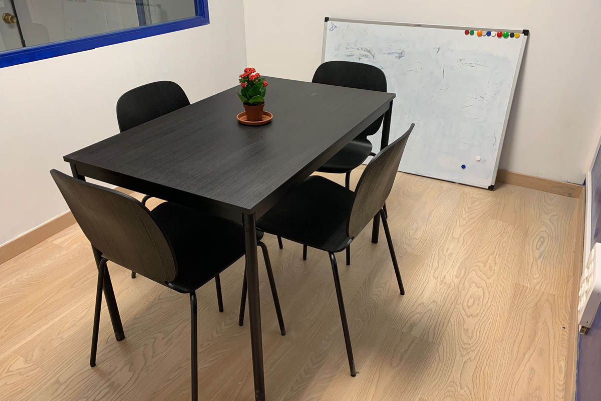Detalle de mesa y sillas en negro en una oficina de CREC Eixample